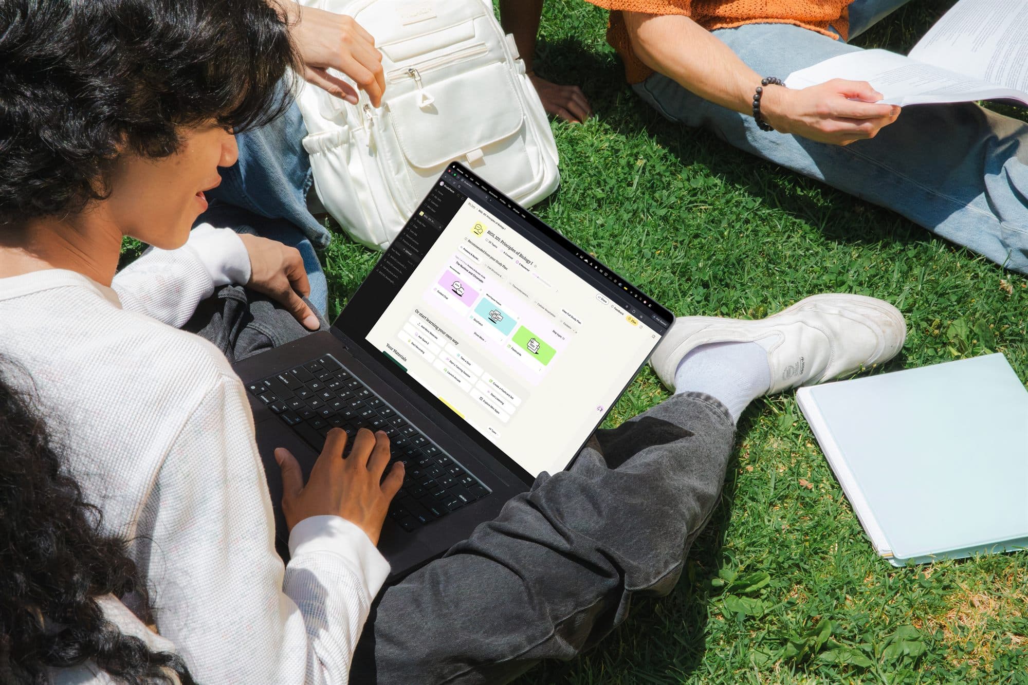 Creator working on a laptop in the grass